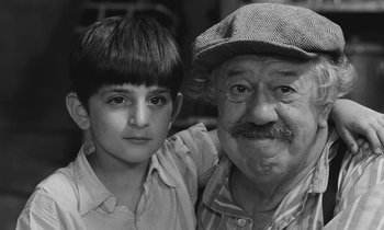 Movie still from “The Two of Us” (1967), directed by Claude Berri – An older man and a young boy posing for a picture; Close Up shot, High angle