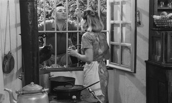 Movie still from “The Two of Us” (1967), directed by Claude Berri – A man and a woman are standing in front of a window; Medium shot, High angle