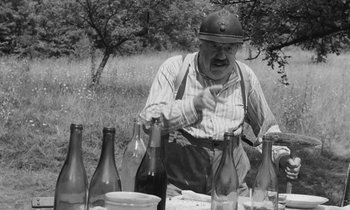 Movie still from “The Two of Us” (1967), directed by Claude Berri – An old man sitting at a table with several empty bottles; Medium shot, High angle