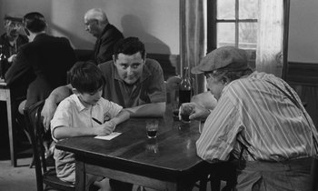 Movie still from “The Two of Us” (1967), directed by Claude Berri – A group of people sitting around a table; Medium shot, Over the shoulder angle