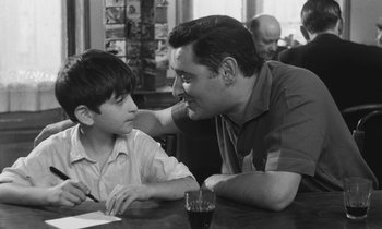 Movie still from “The Two of Us” (1967), directed by Claude Berri – A man and a young boy sitting at a table; Medium shot, Over the shoulder angle