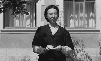 Movie still from “The Two of Us” (1967), directed by Claude Berri – An older woman standing in front of a building; Medium shot, Low angle