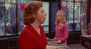 Movie still from “The Umbrellas of Cherbourg” (1964), directed by Jacques Demy – A woman in a red jacket and a girl in a pink sweater; Medium shot, Over the shoulder angle