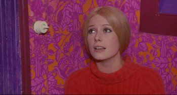 Movie still from “The Umbrellas of Cherbourg” (1964), directed by Jacques Demy – A woman in a red sweater looking up at the ceiling; Close Up shot, Low angle