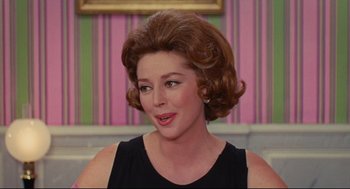 Movie still from “The Umbrellas of Cherbourg” (1964), directed by Jacques Demy – A person wearing a black dress; Close Up shot, Over the shoulder angle