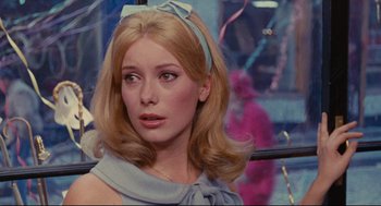 Movie still from “The Umbrellas of Cherbourg” (1964), directed by Jacques Demy – A person with long blonde hair; Close Up shot, Over the shoulder angle