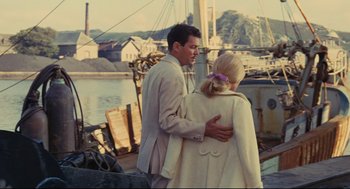 Movie still from “The Umbrellas of Cherbourg” (1964), directed by Jacques Demy – A man and a woman hugging on a boat; Medium shot, Over the shoulder angle
