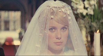 Movie still from “The Umbrellas of Cherbourg” (1964), directed by Jacques Demy – A woman wearing a wedding veil with flowers on top of her head; Close Up shot, Over the shoulder angle
