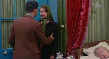 Movie still from “The Umbrellas of Cherbourg” (1964), directed by Jacques Demy – A man and a woman standing in front of a mirror; Medium shot, Over the shoulder angle