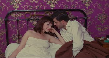 Movie still from “The Umbrellas of Cherbourg” (1964), directed by Jacques Demy – A man and a woman laying in a bed together; Medium shot, Overhead angle