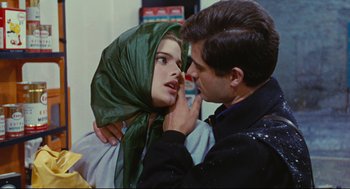 Movie still from “The Umbrellas of Cherbourg” (1964), directed by Jacques Demy – A man and a woman touching their faces; Close Up shot, Over the shoulder angle