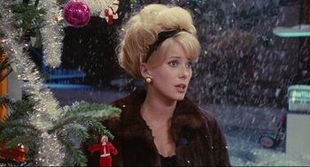 Movie still from “The Umbrellas of Cherbourg” (1964), directed by Jacques Demy – A woman in a fur coat standing in front of a christmas tree; Close Up shot, Over the shoulder angle