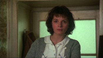 Movie still from “The Unbearable Lightness of Being” (1988), directed by Philip Kaufman – A woman in a white shirt and a sweater; Close Up shot, Over the shoulder angle