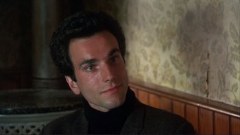 Movie still from “The Unbearable Lightness of Being” (1988), directed by Philip Kaufman – A person wearing a suit; Close Up shot, High angle