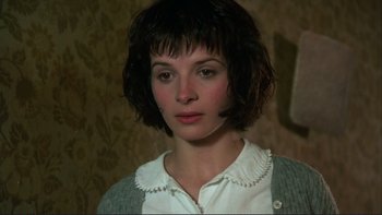 Movie still from “The Unbearable Lightness of Being” (1988), directed by Philip Kaufman – A woman with short black hair wearing a white shirt; Close Up shot, High angle