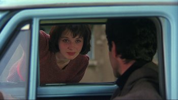 Movie still from “The Unbearable Lightness of Being” (1988), directed by Philip Kaufman – A man and a woman looking at each other in a car mirror; Close Up shot, Over the shoulder angle