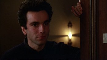 Movie still from “The Unbearable Lightness of Being” (1988), directed by Philip Kaufman – A young man is sitting in a dark room; Close Up shot, Low angle