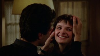 Movie still from “The Unbearable Lightness of Being” (1988), directed by Philip Kaufman – A man touching a woman's face in front of a bathroom mirror; Close Up shot, Over the shoulder angle