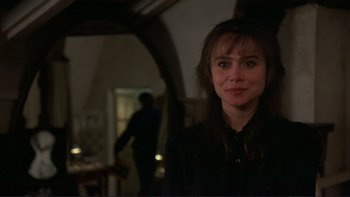 Movie still from “The Unbearable Lightness of Being” (1988), directed by Philip Kaufman – A woman in black shirt standing in a room; Close Up shot, Over the shoulder angle
