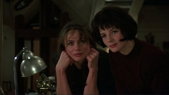 Two women sitting next to each other in front of a lamp