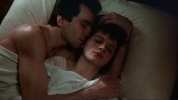 Movie still from “The Unbearable Lightness of Being” (1988), directed by Philip Kaufman – A man and a woman laying in a bed together; Close Up shot, Overhead angle
