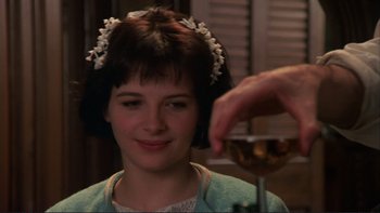 Movie still from “The Unbearable Lightness of Being” (1988), directed by Philip Kaufman – A woman is smiling while a person is holding a glass of wine; Close Up shot, Over the shoulder angle