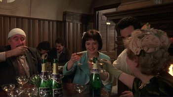 Movie still from “The Unbearable Lightness of Being” (1988), directed by Philip Kaufman – A group of people sitting at a table drinking beer; Medium shot, High angle