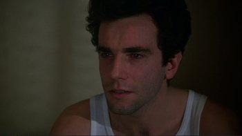 Movie still from “The Unbearable Lightness of Being” (1988), directed by Philip Kaufman – A person wearing a white tank top; Close Up shot, Over the shoulder angle