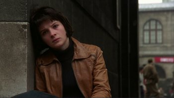 Movie still from “The Unbearable Lightness of Being” (1988), directed by Philip Kaufman – A woman in a brown leather jacket sitting on a chair; Close Up shot, Low angle