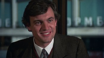 Movie still from “The Unbearable Lightness of Being” (1988), directed by Philip Kaufman – A person wearing a suit and tie; Close Up shot, Over the shoulder angle