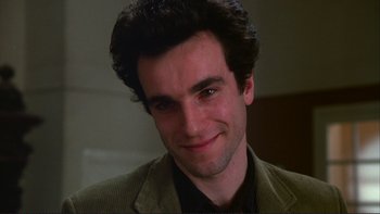 Movie still from “The Unbearable Lightness of Being” (1988), directed by Philip Kaufman – A person wearing a suit and smiling; Close Up shot, Over the shoulder angle