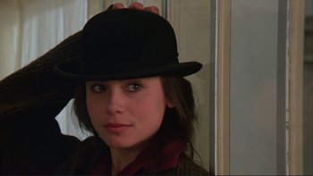 Movie still from “The Unbearable Lightness of Being” (1988), directed by Philip Kaufman – A young woman wearing a black hat and jacket; Close Up shot, Over the shoulder angle