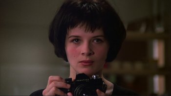 Movie still from “The Unbearable Lightness of Being” (1988), directed by Philip Kaufman – A woman holding a camera in front of a mirror; Close Up shot, Over the shoulder angle