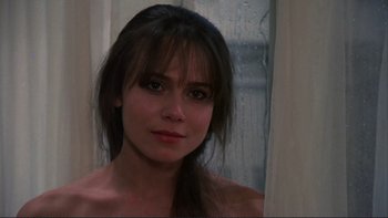 Movie still from “The Unbearable Lightness of Being” (1988), directed by Philip Kaufman – A beautiful woman with long dark brown hair and green eyes; Close Up shot, Over the shoulder angle