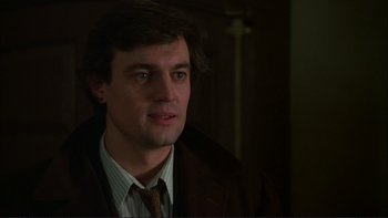 Movie still from “The Unbearable Lightness of Being” (1988), directed by Philip Kaufman – A person wearing a suit and tie; Close Up shot, Over the shoulder angle