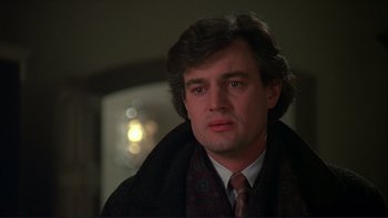 Movie still from “The Unbearable Lightness of Being” (1988), directed by Philip Kaufman – A person wearing a suit and tie; Close Up shot, Over the shoulder angle