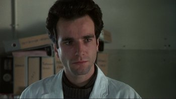 Movie still from “The Unbearable Lightness of Being” (1988), directed by Philip Kaufman – A person wearing a white lab coat; Close Up shot, Low angle