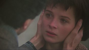 Movie still from “The Unbearable Lightness of Being” (1988), directed by Philip Kaufman – A woman looking into a mirror while holding her hand to her ear; Close Up shot, Over the shoulder angle