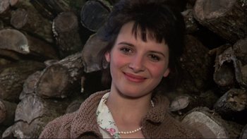 Movie still from “The Unbearable Lightness of Being” (1988), directed by Philip Kaufman – A person wearing a sweater near a pile of wood; Close Up shot, Over the shoulder angle