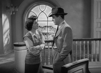Movie still from “The Uninvited” (1944), directed by Lewis Allen – A man and a woman standing next to each other in front of a window; Medium shot, High angle