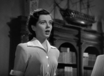 Movie still from “The Uninvited” (1944), directed by Lewis Allen – A woman standing in front of a book shelf; Close Up shot, Low angle