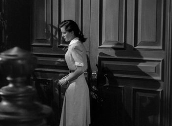 Movie still from “The Uninvited” (1944), directed by Lewis Allen – A black and white photo of a woman standing in front of a wall; Medium shot, High angle
