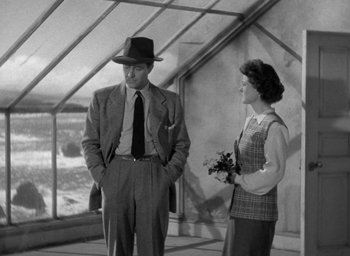 Movie still from “The Uninvited” (1944), directed by Lewis Allen – An old photo of a man and a woman standing in front of a window; Medium shot, Low angle