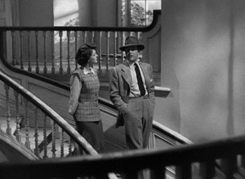 Movie still from “The Uninvited” (1944), directed by Lewis Allen – A man and a woman are standing on a staircase; Medium shot, Low angle
