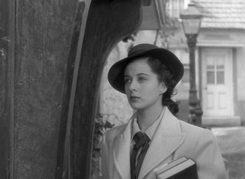 Movie still from “The Uninvited” (1944), directed by Lewis Allen – A woman in a suit and hat holding a book; Close Up shot, Low angle