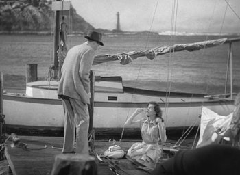 Movie still from “The Uninvited” (1944), directed by Lewis Allen – An older man and a young woman sitting on the deck of a sail boat; Wide shot, High angle