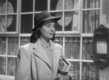 Movie still from “The Uninvited” (1944), directed by Lewis Allen – A woman wearing a hat and holding a book; Medium shot, Low angle