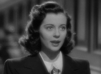 Movie still from “The Uninvited” (1944), directed by Lewis Allen – A black - and - white photo of a woman wearing a suit and tie; Close Up shot, High angle