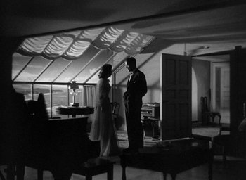 Movie still from “The Uninvited” (1944), directed by Lewis Allen – A man and a woman standing next to each other in a room; Wide shot, Low angle