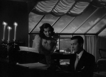 Movie still from “The Uninvited” (1944), directed by Lewis Allen – A man and a woman sitting in front of a piano; Medium shot, Low angle